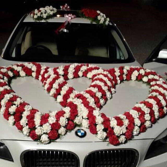 Vehicle Decor intertwined with red and white floral garlands arranged in the shape of two hearts
